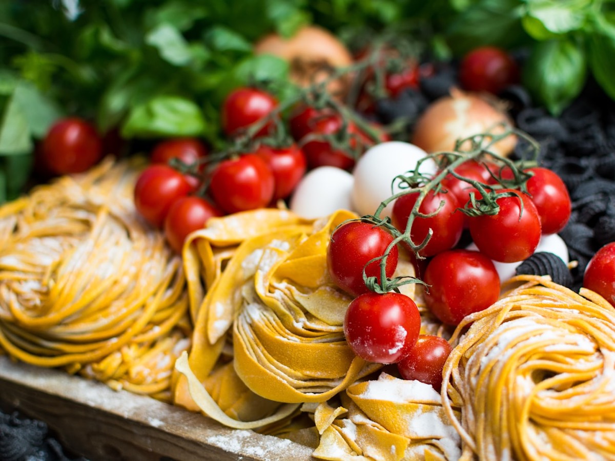 Frische Bandnudeln mit Tomaten und Basilikum (Stimmungsbild).